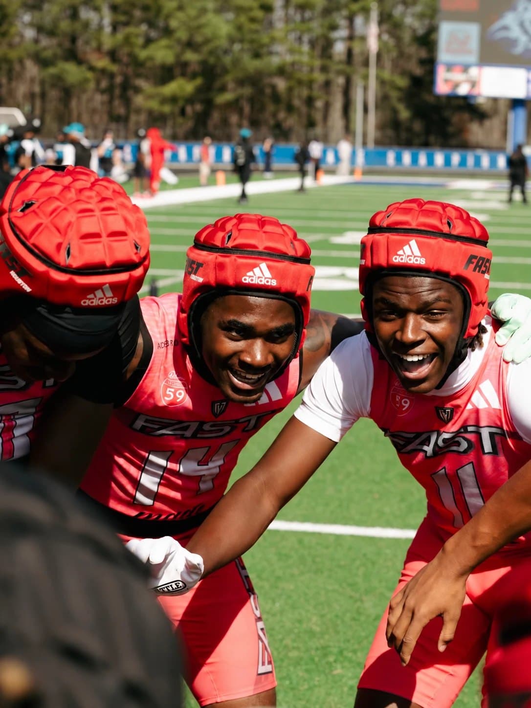 7-on-7 athletes huddled together on the field at a league event